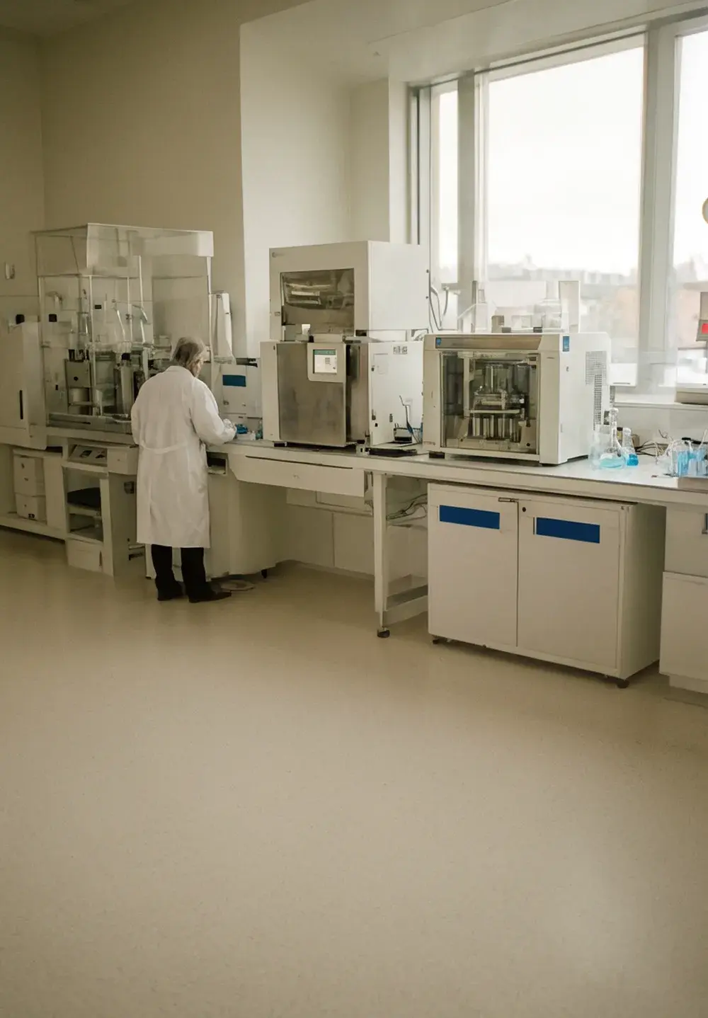 A scientist in a clean genomics lab lit by soft blue instrument glow